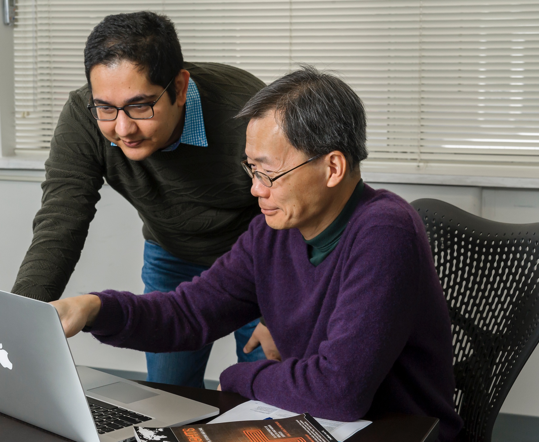 Scientists Drs. Hubert Wong and Ehsan Karim analyze data on computer, medical device clinical studies